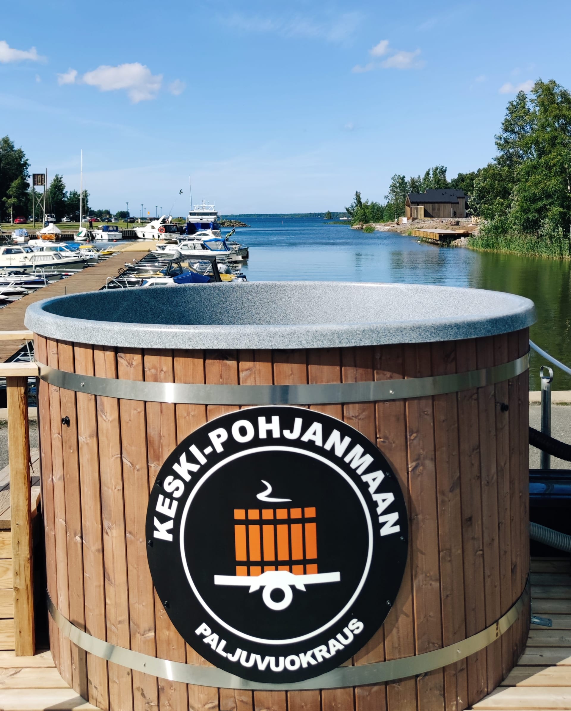 Puinen paljukärry rannassa, kyljessä Keski-Pohjanmaan Paljuvuokrauksen logo
